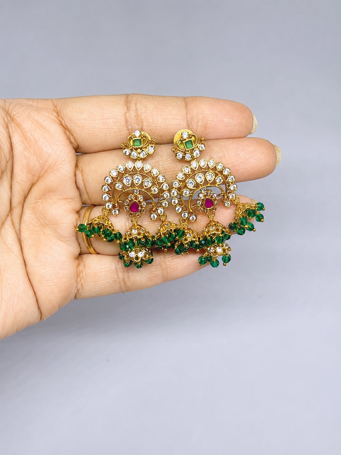 gold-finish chandelier with green beaded earrings